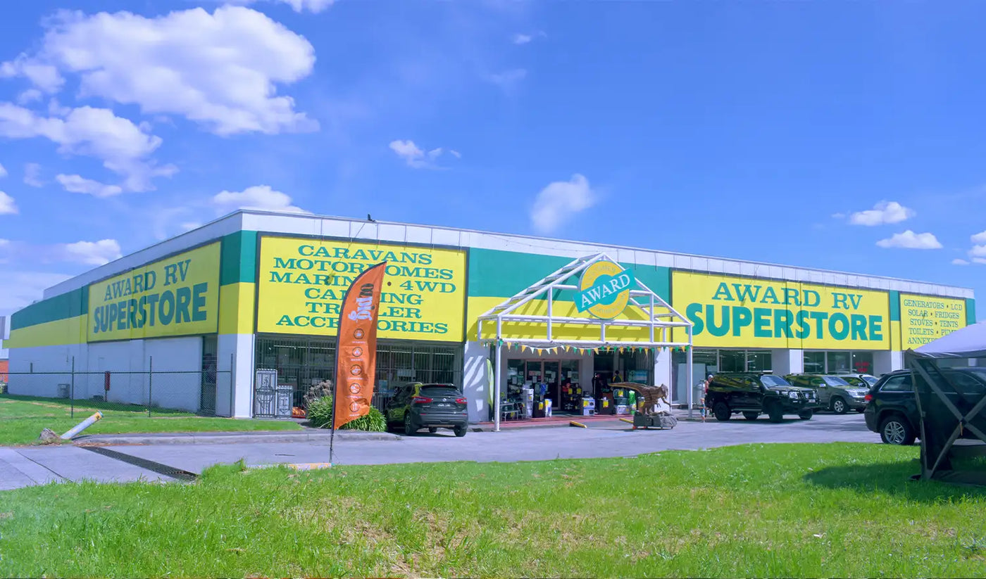 Award RV Superstore with yellow and green facade under a blue sky.